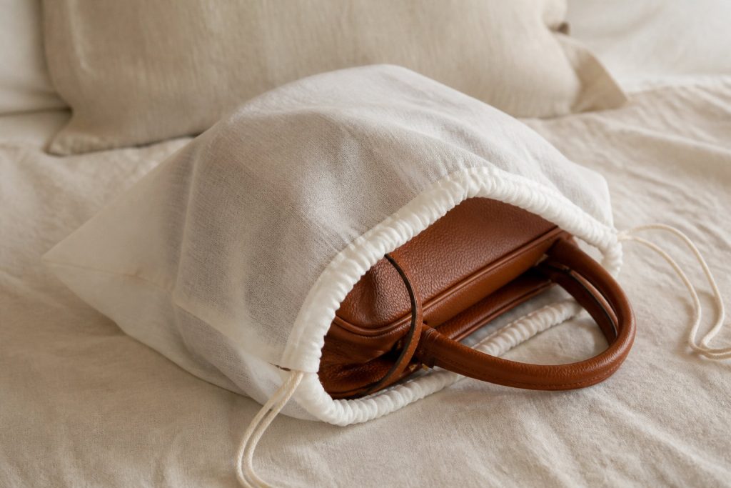 Sac à main en cuir rangé dans un pochon de protection en tissu