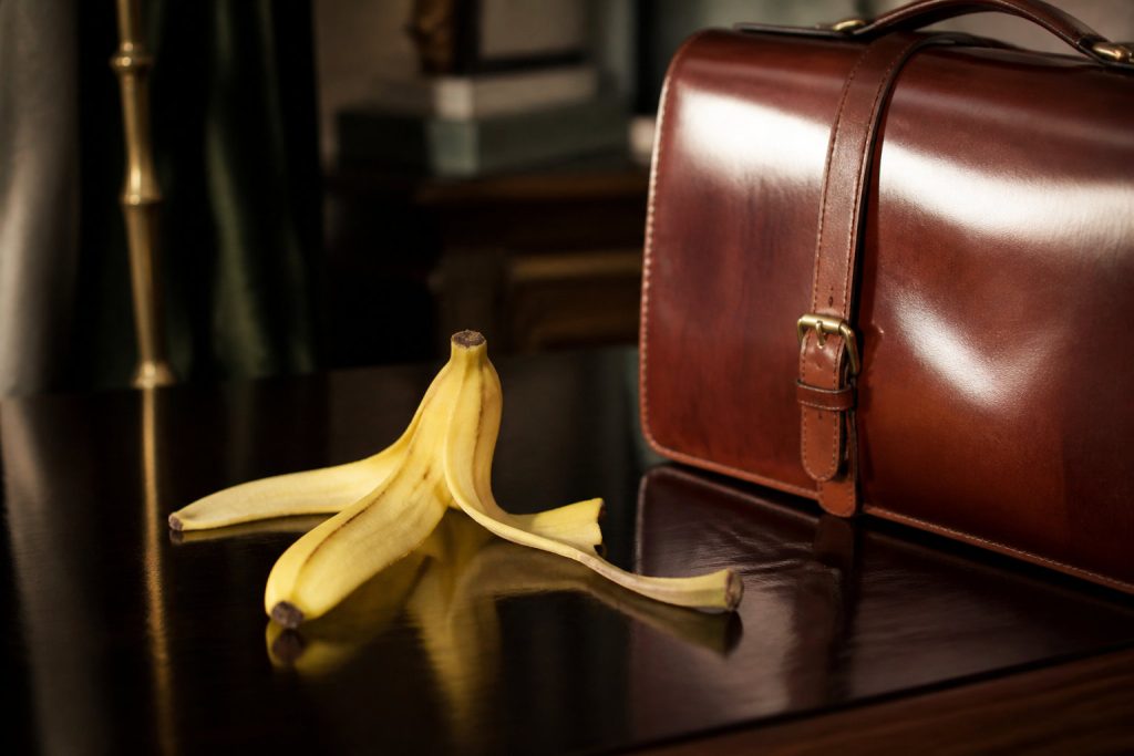 Peau de banane posée à côté d'une sacoche en cuir